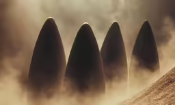 four tall rock outcrops on the side of a dirt road