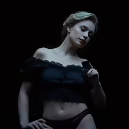 woman posing with cell phone in dark room