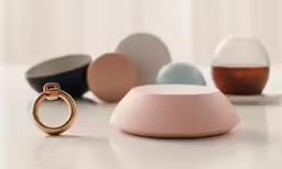 three rings on top of a table in front of two empty glass vases