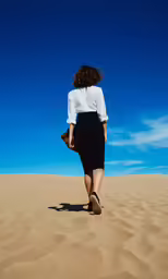 a woman walking in the desert, looking up at the sky