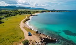 there is a car driving along the beach