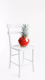 a chair with a small pineapple on the seat