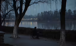 a man sitting on a park bench at night