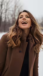 a young woman in brown coat outside in the snow
