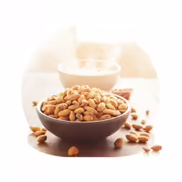 a bowl filled with nuts on top of a wooden table
