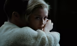 a man sitting next to a woman while holding her head
