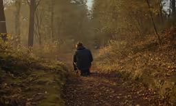 a person sitting on a bench in the woods