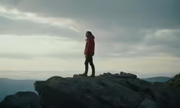 a man stands on the top of a rock