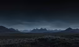 a mountain range is seen in the distance at night