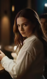 a woman in white coat holding a cellphone by candle light