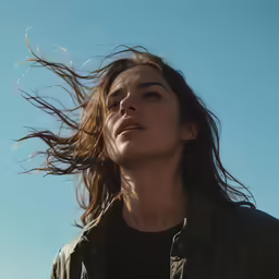 a young woman with wind blowing her hair outside