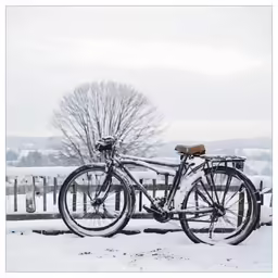 two bicycles that are parked in the snow