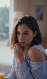 woman looking off camera with glass of orange juice