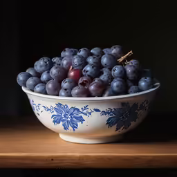 a bowl filled with grapes and grapes on top of a table