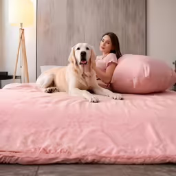 a woman with her large dog laying on a pillow