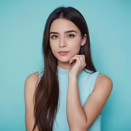 a woman in a blue shirt standing on a turquoise background