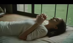 a pregnant woman lays on her stomach in bed