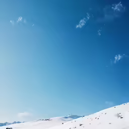two people skiing on a snowy hill in the mountains