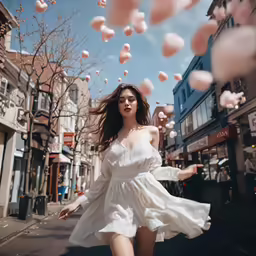 the young lady is walking down the sidewalk with the balloons