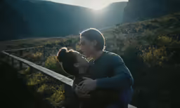 a woman hugging her husband outside in the woods
