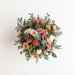a bouquet of orange and pink flowers and greenery