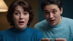 the boy and the girl are both playing the nintendo wii