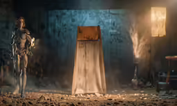 a man dressed as a knight and woman holding swords are standing in a stone - walled barn