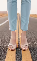 a pair of legs wearing blue jeans and high heel sandals