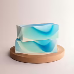 two blue soap bars sitting on a brown board