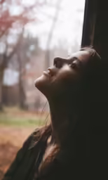 the head of a woman looking out of the window