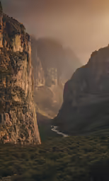 a very tall rocky mountain sitting next to a river