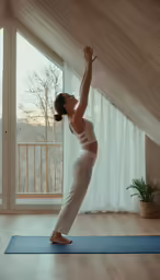 the woman in white clothes is practicing her yoga moves