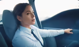 a business woman smiling while driving a car