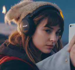 the girl wearing headphones is holding her cell phone