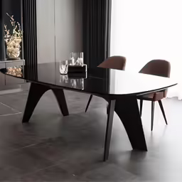 a table sitting next to chairs and a bookcase
