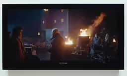 a movie scene of some people gathered around a fire