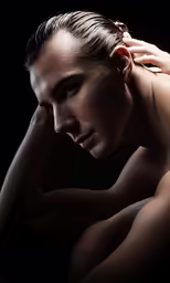 the topless man is leaning on his arm