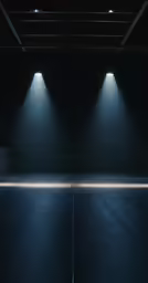 a dark room with three lights shining over the floor