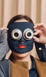 a woman putting a face mask on her eyes