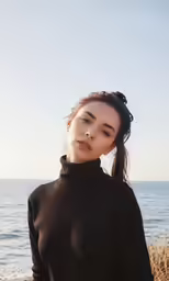 a woman is standing on the beach looking down