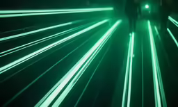 a couple walking through a green tunnel with a light trail in the dark