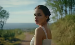 a woman posing on a country road wearing a strapless gown