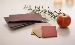 a piece of paper next to an apple and some leaves