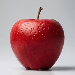 an apple with water drops on it and a bite taken out