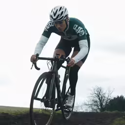 a man riding a bike down a dirt road