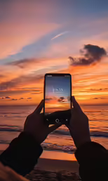 someone is holding their phone up to take a photo of the beach
