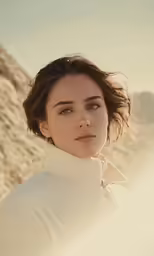 a woman wearing white in the desert with her hair blown back