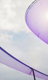 a purple kite flying across the sky above another purple one