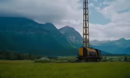 the oil rig is in a field of green grass