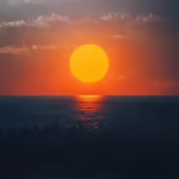 the sun is setting over the ocean and clouds